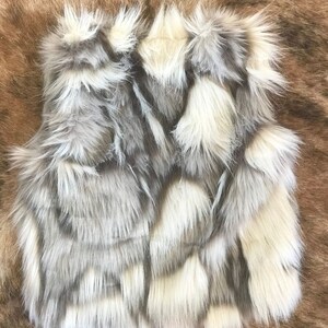 Cozy and stylish Kids' Fur Vest in a blend of grey, black, brown, and cream. Perfect for layering over any outfit, this well-made vest keeps your child warm and photo-ready. The versatile colors make it easy to mix and match with her wardrobe.