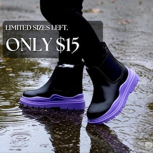 May include: Black ankle boots featuring a smooth upper, elastic side panels, and a thick, chunky purple rubber sole with a deep tread pattern. The boots are worn with black leggings and are positioned in a shallow pool of water with ripples.