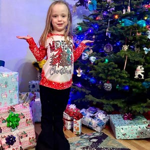 Jernie modeling MerryChristmas shirt and black jeans sold separately