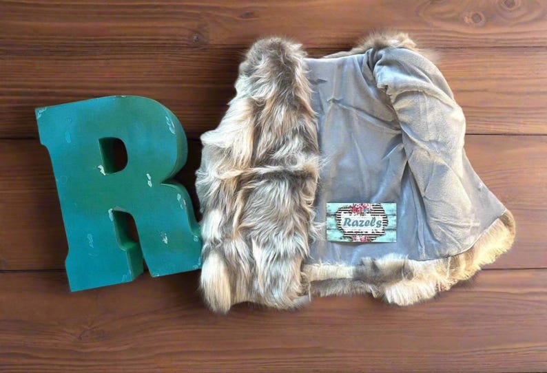 Cozy and stylish Kids' Fur Vest in a blend of grey, black, brown, and cream. Perfect for layering over any outfit, this well-made vest keeps your child warm and photo-ready. The versatile colors make it easy to mix and match with her wardrobe.