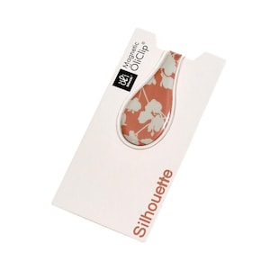 May include: A pink and white floral patterned magnetic oil clip, labelled "Magnetic OilClip" and "Silhouette".