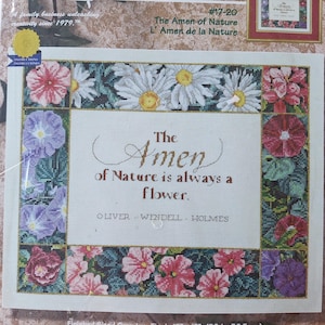 May include: Cross stitch pattern featuring a floral border with a quote by Oliver Wendell Holmes: "The Amen of Nature is always a flower."