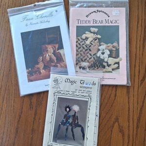 May include: Three sewing patterns in plastic bags. The first pattern is for a faux chenille tiger, the second is for a teddy bear quilt, and the third is for a cloth doll called "Widgets".