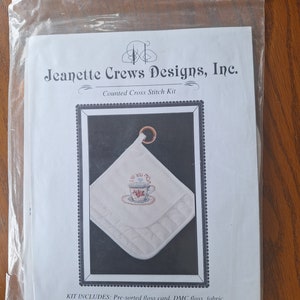 Peut inclure: Un kit de point de croix compté pour un chauffe-tasse avec un fond blanc et une tasse à thé brodée avec les mots "Je t'aime Maman". Le kit comprend du fil pré-trié, du fil DMC, du tissu, une aiguille, un graphique et des instructions.
