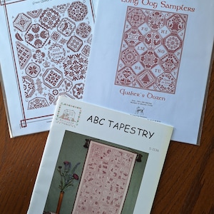 May include: Three cross stitch patterns, two are for samplers and one is for an alphabet tapestry. The sampler patterns are titled "Grace Quaker Sampler" and "Quaker's Dozen". The alphabet tapestry pattern is titled "ABC Tapestry".