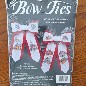 Puede incluir: Un kit de punto de cruz para hacer dos adornos de lazo de pajarita con un tema de pueblo de campo. El kit incluye tela Aida de algodón 100%, cintas preacabadas, hilo de bordar preclasificado, tela de aguja para pestañas de cinta e instrucciones. El tamaño terminado de cada pajarita es de aproximadamente 10 cm por 15 cm.