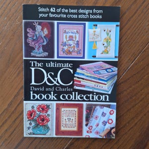 May include: A book cover displaying the title "Stitch 62 of the best designs from your favourite cross stitch books." The book is titled "The ultimate D&C David and Charles book collection." The cover features various cross-stitch designs.