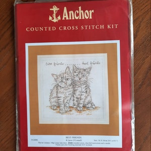 May include: A red Anchor counted cross stitch kit featuring two kittens labeled "Best Friends." The kit includes Aida fabric, stranded cotton, instructions, and a needle. The finished size is 6 x 6 inches.