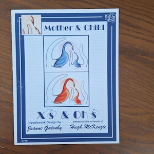 Op de afbeelding: Een borduurpatroon met twee gestileerde vogels, een blauwe en een rode, met de titel "Mother & Child" en de tekst "Xs & Oh's" met de namen "Joanne Gatenby" en "Hugh McKenzie".