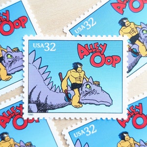 May include: Five vintage postage stamps featuring the comic strip character Alley Oop. Each stamp depicts Alley Oop riding a dinosaur, with the text "ALLEY OOP" and "USA 32" printed on each stamp.