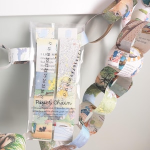 May include: A paper chain garland featuring colourful illustrations and numbers. The garland is made from recycled paper and is ideal for adding a touch of whimsy to any room.