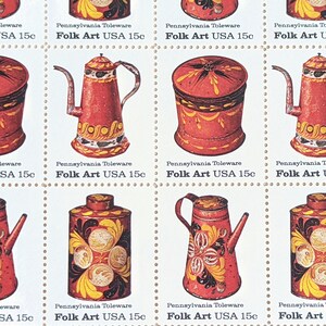 Könnte beinhalten: Acht Briefmarken im Vintage-Stil mit Pennsylvania Toleware Folk Art. Jede Marke zeigt ein anderes rot, gelb und weiß bemaltes Objekt, darunter eine Teekanne, ein abgedeckter Behälter und ein Krug. Die Briefmarken sind alle 15 Cent wert und tragen den Text "Pennsylvania Toleware Folk Art USA 15c".