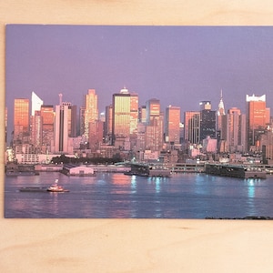 New York inutilizzata, skyline di Manhattan al tramonto lungo il fiume Hudson Cartolina, merce della città