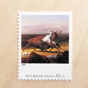 May include: A 1998 United States postage stamp featuring a painting by Albert Bierstadt (1830-1902) depicting a Native American on horseback chasing a buffalo. The stamp is white with a blue and white image of the painting.