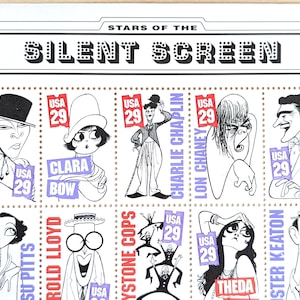 以下が含まれることがあります： サイレント映画スターを白黒で描いた、アメリカのヴィンテージ切手シート。ルドルフ・ヴァレンチノ、クララ・ボウ、チャーリー・チャップリン、ロン・チェイニー、シーダ・バラ、バスター・キートン、ジョン・ギルバートなどが描かれている。各切手には「USA 29」と印刷されている。シートのタイトルは「Stars of the Silent Screen」。