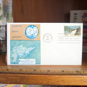 May include: A white envelope with a Tennessee Valley Authority stamp and a Knoxville, TN postmark dated May 16, 1983. The stamp features a dam and the words "First Day of Issue". The envelope also has a map and portraits of Roosevelt and Garner.