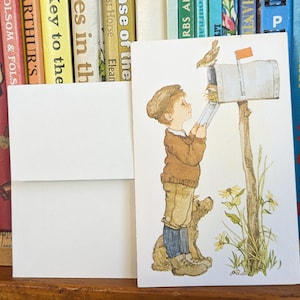 May include: A vintage illustration of a young boy in a brown sweater and blue jeans standing by a mailbox. A small bird is perched on the mailbox, and a dog is sitting beside the boy. The scene is set in a rural setting with green grass and wildflowers.