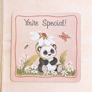 May include: A pink card with a red border and the text "You're Special!" in black. A cartoon panda bear wearing a daisy on its head sits in a field of daisies and butterflies.