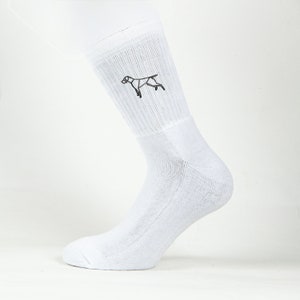 May include: White crew socks with a geometric dog design embroidered on the side.