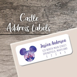 May include: A white oval address label with a purple watercolor illustration of a castle in a Mickey Mouse ear shape. The label has the text "Jessica Anderson", "125 North Main Street", "Springfield, Maryland", and "1 2 3 4 5".