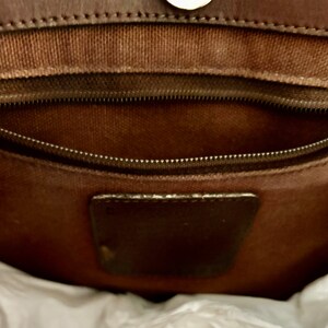 Puede incluir: El interior de un bolso de cuero marr&oacute;n con un bolsillo con cremallera y un parche de cuero marr&oacute;n.