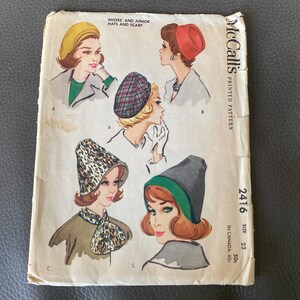 Może przedstawiać: Wzorzec szycia vintage McCall's do kapeluszy i szalika. Numer wzoru to 2416, rozmiar 22 i kosztuje 50 centów. Wzór pokazuje cztery różne style kapeluszy: żółtą beretkę, beret w kratkę, kapelusz typu cloche z nadrukiem lamparta i czarny i zielony kapelusz typu cloche.
