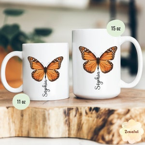 Peut inclure: Deux tasses en c&eacute;ramique blanche avec un motif de papillon monarque et le nom "Sophia" imprim&eacute; dessus. La tasse de gauche est de 11 oz et la tasse de droite est de 15 oz.