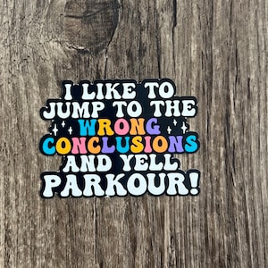 May include: A black and white sticker with the text "I like to jump to the wrong conclusions and yell parkour!" in colorful letters.