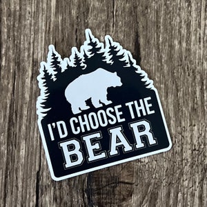 May include: Black and white sticker featuring a silhouette of a bear in a forest. The text "I'd Choose The Bear" is written below the bear.