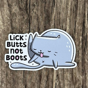 May include: A sticker featuring a light blue cartoon cat licking its paw. The sticker has the text "LICK BUTTS NOT BOOTS" in black, with white accents. The cat is drawn with its eyes closed and tongue sticking out.