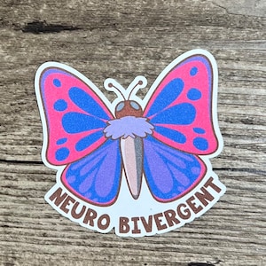 May include: A sticker with a purple and blue butterfly with pink accents and brown spots. The butterfly has a brown body and a fuzzy purple thorax. The text "Neuro Divergent" is written in brown around the butterfly.