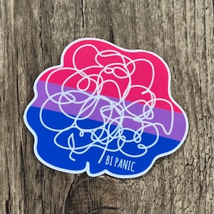 May include: A sticker with a white squiggly line on a background of pink, purple, and blue stripes. The text "BI PANIC" is written in white at the bottom of the sticker.
