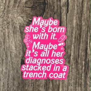 Peut inclure: Un autocollant rose vif avec du texte blanc qui dit : Maybe she's born with it. Maybe it's all her diagnoses stacked in a trench coat. Le design comprend de petites illustrations blanches de pilules rondes et une gélule autour du texte.