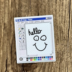 May include: A rectangular sticker featuring a retro computer software interface titled No AI Slop - Paint. The design includes a toolbar with various drawing icons, a white canvas area with the handwritten word hello and a simple smiley face drawing.