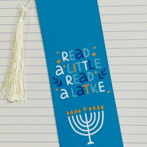 May include: Blue bookmark with a white tassel. The bookmark features a menorah and the text "Read a little, read a latke."