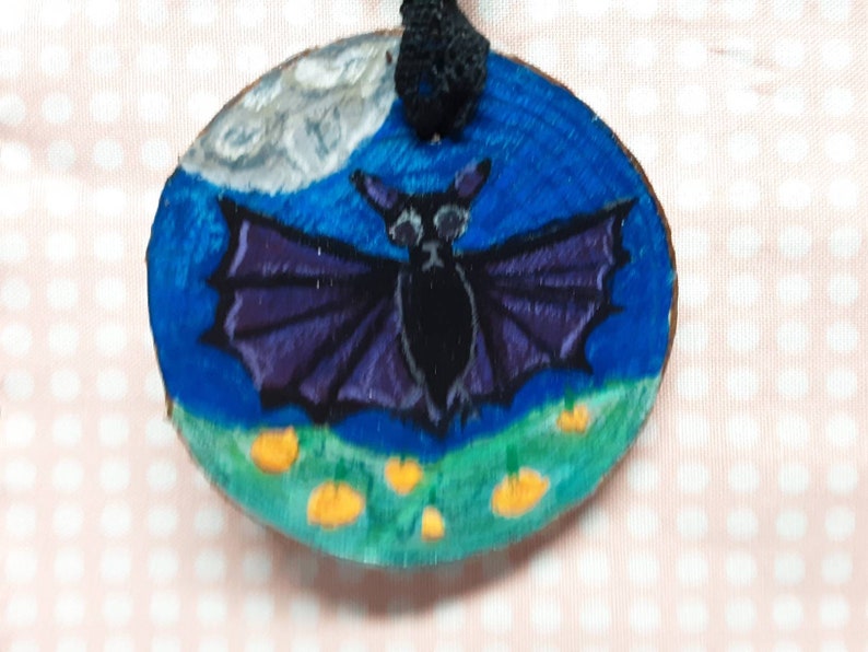 Black bat in a pumpkin field during a full moon wood ornament painting