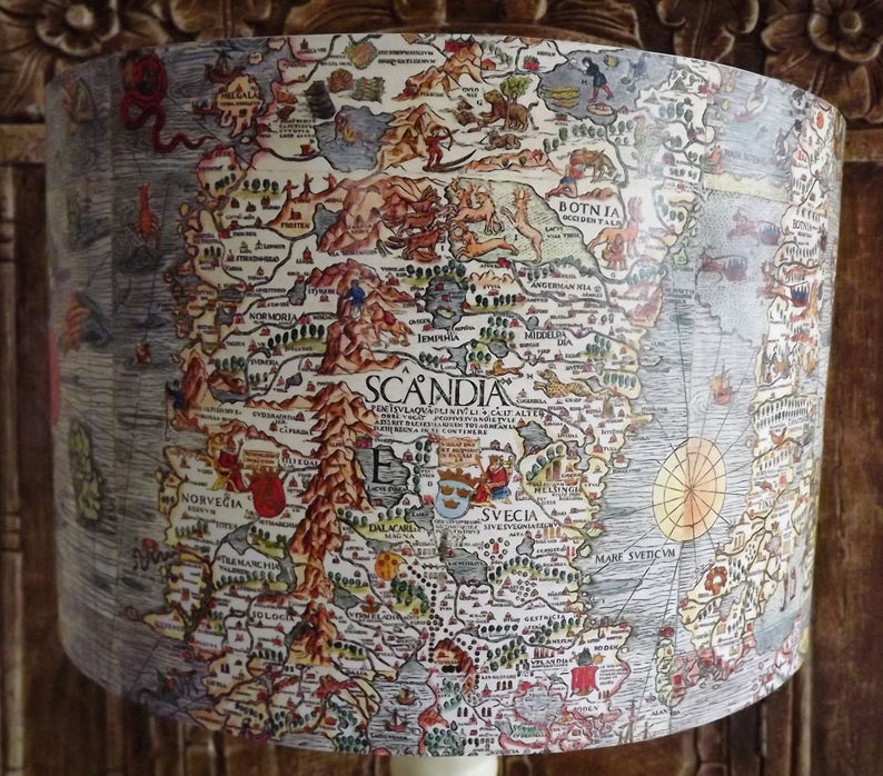 May include: A vintage map of Scandinavia, printed on a lampshade. The map is in a detailed, illustrated style, with a focus on the Scandinavian peninsula. The map is surrounded by a light blue border.