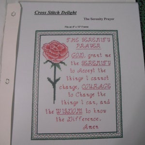 May include: Cross stitch pattern for the Serenity Prayer, featuring a pink rose with green leaves and a white background. The text reads: "THE SERENITY PRAYER GOD, grant me the SERENITY to Accept the things I cannot change, COURAGE to Change the things I can, and the WISDOM to know the Difference. Amen."