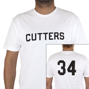 May include: White t-shirt with "CUTTERS" printed on the front and the number "34" printed on the back.