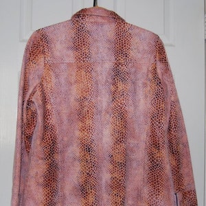 May include: A pink and brown snakeskin patterned jacket with zippered cuffs.