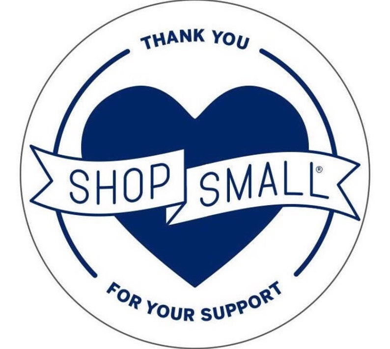 Pode incluir: Etiqueta circular branca com um cora&ccedil;&atilde;o azul e uma faixa branca que diz "SHOP SMALL" em letras mai&uacute;sculas. O texto "THANK YOU" aparece acima do cora&ccedil;&atilde;o e "FOR YOUR SUPPORT" aparece abaixo do cora&ccedil;&atilde;o.