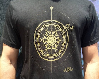 May include: Black t-shirt with a gold geometric design featuring a starburst pattern and the word "enlighten" printed on the bottom.