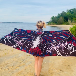 May include: A black beach towel with a colorful eagle design, roses, and the words "Forever Grateful".