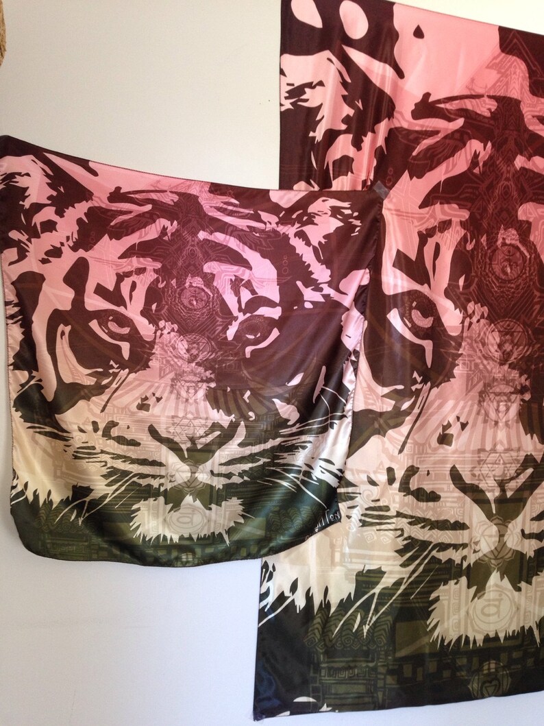 May include: A silk scarf with a tiger face design. The scarf features a gradient of colors, including pink, brown, and green. The tiger's face is prominently displayed, with intricate details and patterns. The scarf is a stylish accessory.