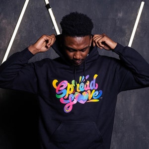 May include: A black hooded sweatshirt with a colorful graphic print that says "Spread Love" with a heart design.