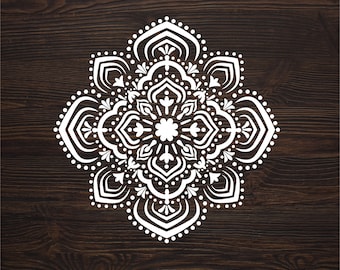 May include: White mandala design on a dark brown wood background. The mandala is intricate and detailed, with a circular pattern of flowers and leaves.