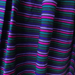 May include: A black skirt with horizontal stripes in shades of purple, blue, and green.