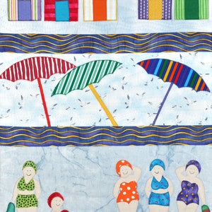 May include: A colorful quilted wall hanging featuring five beach houses, three striped umbrellas, and five women wearing swimsuits and swim caps. The beach houses are purple, red, yellow, blue, and green. The umbrellas are red and white, green and white, and blue and white. The women are wearing red, orange, blue, and purple swimsuits. The background is a light blue with a wavy blue and yellow stripe.