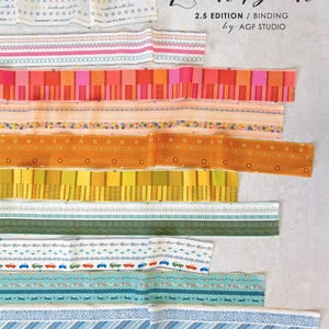 Może przedstawiać: Kolekcja kolorowych pasków materiału z różnymi wzorami, w tym kwiatowymi i geometrycznymi, na jasnym tle. Widoczny jest tekst "Look Book" oraz "2.5 EDITION / BINDING by AGF STUDIO".