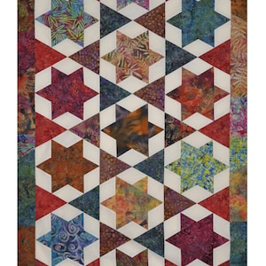 Puede incluir: Un edredón colorido con un diseño de estrellas. El edredón presenta estrellas en varios colores, incluyendo rojo, azul, naranja y morado, sobre un fondo blanco. El borde del edredón es una mezcla de telas estampadas.